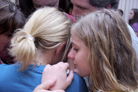 Nicole Hamilton, sister of Ashley Hamilton, prays with her family for her sister after the New Student Orientation Chapel.