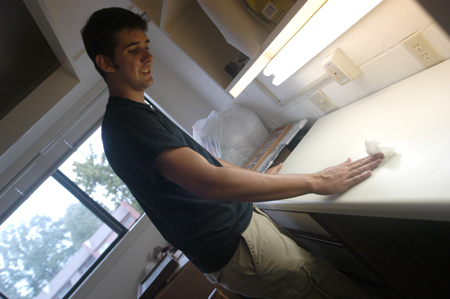 Freshman Josh Hays of Murfreesboro, Tenn. cleans off his desk before unpacking on Freshman Move-In Day.