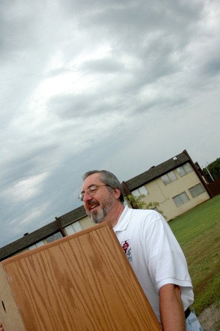 Sam Myatt, director of academic services for continuing studies, helps new students move in under some menacing clouds on Freshman Move-In Day.
