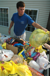 09/5/05 - Senior Brett Logan assists in sorting goods donated to Hurricane Katrina victims.  Union students left bags on doorsteps over Labor Day weekend throughout Jackson and collected them, sorted them into different categories between Hurt and Watters Commons, then delivered them to West Jackson Baptist Church. - Brad Moore