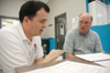Matt Lunsford and Bryan Dawson, professors of mathematics, assist the Boys and Girls Club of Jackson in compiling results from a survey during the Day of Remembrance. - Photo by Brad Moore