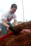 Senior Paul Akin loads up a wheelbarrow with mulch for landscaping at the Boys and Girls Club of Jackson during the Day of Remembrance. - Photo by Brad Moore