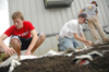 Joe Cadden, Jordan Atwell, and Brett Logan help lay down newspaper and soil for a new garden at Parkview Montessori during their Day of Remembrance service project. - Photo by Kristen Nicole Sayres