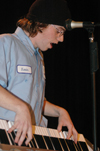 Sophomore Nathan Brewer recites poetry set to music as he plays his electronic keyboard upright during Cafe Bongo. - Photo by Brad Moore