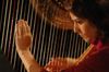 Senior Joy Ledden plucks the strings of her harp during Cafe Bongo. - Photo by Brad Moore
