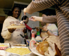 Purity Ogolla gets a second helping of turkey at the International Student Thanksgiving dinner hosted by Mario Cobo. - Photo by Kyle Kurlick