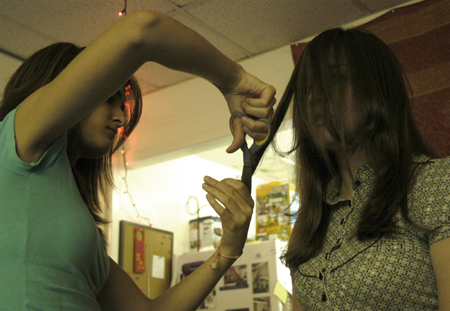 Kristmar Rawlins trims Kayli Anthony's hair in their dorm room.