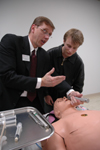 Mark Kossick, program director of the nurse anesthesia program, demonstrates the Human Patient Simulator during the nursing homecoming gathering. - Photo by Kristen Nicole Sayres