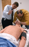 3/2/06 - Mark Kossick, director of the nurse anesthesia program, demonstrates the Human Patient Simulator to graduate stuedent Dale Viox. - Heather Phillips