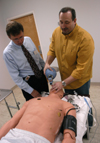 3/2/06 - Mark Kossick, director of the nurse anesthesia program, demonstrates the Human Patient Simulator to graduate stuedent Dale Viox. - Heather Phillips