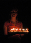 03/9/06 - Katrina Parker brings in a flaming cake for Kristin Jenning's birthday.
