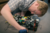Junior Kendal Hershberger works on programming his robot made of Lego parts. The goal of the robot is to grab, pick up and solve the Rubik's cube based on a pattern from a computer program. - Photo by Kyle Kurlick
