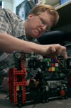 Junior Kendal Hershberger works on programming his robot made of Lego parts. The goal of the robot is to grab, pick up and solve the Rubik's cube based on a pattern from a computer program. - Photo by Kyle Kurlick