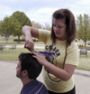 Sophomore Sally Goulooze trims Chris Rigney's hair
outside of the Barefoot Student Union while enjoying the nice spring weather. - Photo by Stephanny Rodriguez