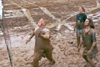 Freshman Jonathan Blair, Freshman Seth Massa, and Sopohomore Tiffany Windall await the ball for the next play in an intramural mud volleyball game. - Photo by Janelle Sou