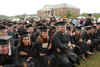 Spring graduates who had already been through the line honored the rest of the graduates by staying to the end in the rain. - Photo by Morris Abernathy