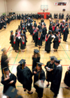 Graduates and faculty members gathered in the small gym to line up before the spring graduation ceremony. - Photo by Matthew Diggs
