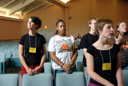 Freshman Lydia Livingston looks skyward as Renee Hayes and Jill Zimmer sing during worship at New Student Orientation.