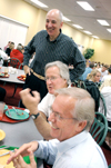 Jim Veneman, instructor of communication arts, makes a point during a New Student Orientation dinner which Steve Beverly, acting chair of communication arts, and Wayne Johnson, associate professor of communication arts, find amusing. - Photo by Kristen Nicole Sayres