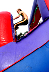 Junior John Kay goes airborne on a water slide during LXA's Bid Day. - Photo by Brad Moore