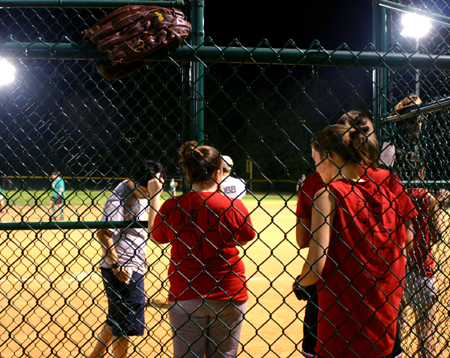 Jonathan Choi, Courtney Ford and Angela White wait for their time at bat during an intramural softball game.