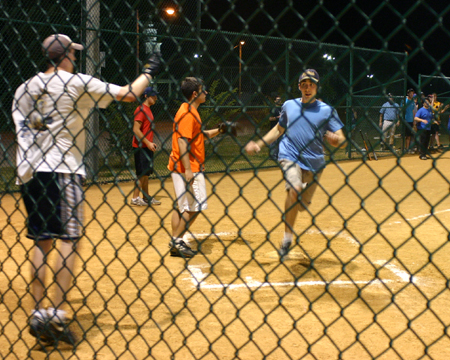 David Roach waves in Drew Zimmer during an intramural softball game.