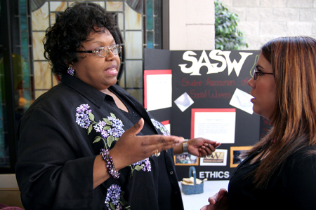 Roslyn Wilson, associate professor of social work and coordinator of Social Work Awareness Day,
consults with senior Lindsay Lawrence in front of the SASW booth in the Student Union Building.