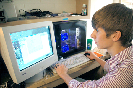 Freshman Stephen Lynch, business management major and residential network technician for computing services, works on a residential computer.