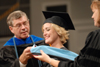 Randy Shadburn and Carla Sanderson place the doctor of education hood over Heather Fisher's head during summer graduation. - Photo by Morris Abernathy