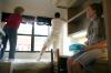 Sister Samantha Cooper watches her brother, Michael and grandmother Diana install a curtain in Michael's dorm room.
 - Photo by Kyle Kurlick
