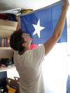 Peter Boedeker sets up his Texas flag while his parents help him unpack during freshman move-in day. - Photo by Kyle Kurlick