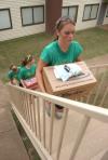 Oliva Poteete, Madison Acadamy High School student,  Rachel Moore, sophomore English major, and Elizabeth Walker, sophomore digital media studies major, all help carry things up the stairs to a freshmen's room. - Photo by Heather Phillips