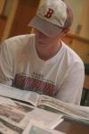 Senior David Roach, sports editor, reviews other newspapers at the Cardinal & Cream retreat to get new ideas for the new year. - Photo by Stephanie Schroeder