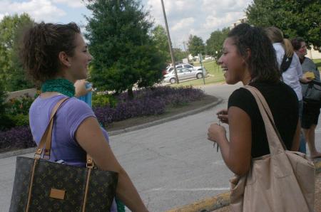 Lydia Livingston talks with freshman Kimberly Middleton, from Olive Branch, Tenn., while they wait on rides to tour Jackson during New Student Orientation.