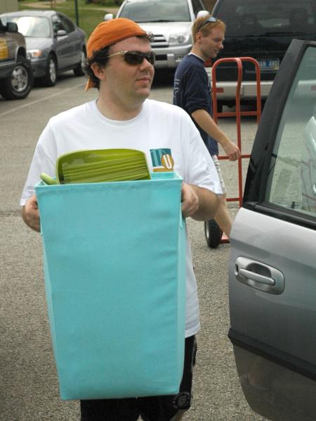 Junior Josh Clarke helps freshman move in during New Student Orientation.