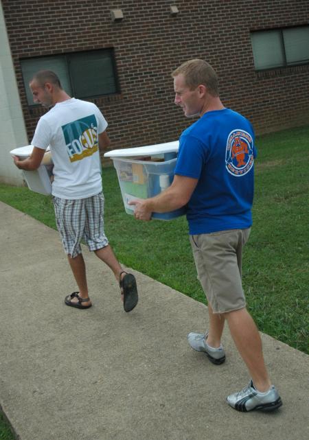 Senior Joel Polk and Matt Brunet, director of wellness services, assist freshmen as they move in during New Student Orientation.