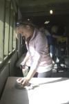 Freshman Molly Burns, undecided major, wipes down one of the tables in the barracks at Youth Town for her Day of Remembrance project. - Photo by Heather Phillips