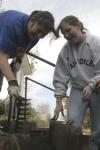 Megan Ditter and Miranda Lindsey work on a garden bed at The Care Center during Day of Remembrance. The girls weeded out the bed then used a rake to make sure they did not miss any weeds. - Photo by Kyle Kurlick