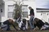 Lily Zopfi, Carolyn Jennings and Carly Ford weed out a walkway at The Care Center while some of their co-workers go in for lunch during Day of Remembrance. - Photo by Kyle Kurlick