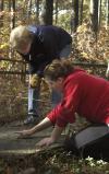 Judy LeForge, associate professor of history, and Senior Cassie Harris inspect a gravestone at the Ames Plantation during a Day of Remembrance project. - Photo by Matthew Diggs