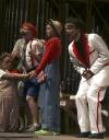 Within her house of straw, that consisted of Julie Palmer as Little Miss Muffet, Katie Patterson as Mistress Mary, and Caitlin Riggs as Mrs. Sprat, Emily Watlington as Amadeus the pig is surprised by a visit from the wolf played by Andy Morris in <em>The Trial of the Big Bad Wolf</em>. - Photo by Kyle Kurlick