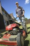 Mike Growe goads his mower forward inside the Hurt Residence Complex, taking care to mow in straight even lines. Wherever grass is inaccessible by riding mower, such as inside the complexes, groundskeepers must use a push-mower. - Photo by Matthew Diggs