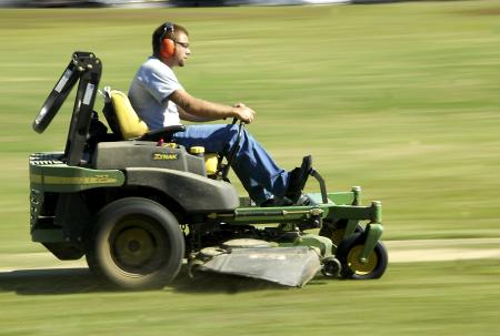 Matt Brasfiled rides a John Deere zero-turn mower around Dement Drive. Riding mowers are used to cover hundreds of acres every week. 