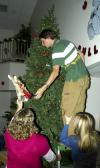 11/27/06 - Sophomore Jonathan Moore, management major, puts the angel on top of the Christmas tree in McAfee commons, as Junior Katie Kulow, learning foundations major, and Junior Courtney Nute, nursing major, assist in the effort during a Christmas decorating party in McAfee commons. 