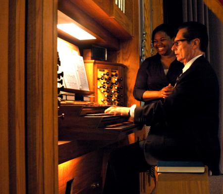 Ronald Boud, professor of music, plays the organ during Fall Convocation as Senior Jennifer Nelson, music performance major, assists in turning the sheet music.