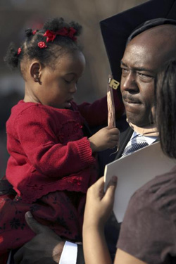 12/16/2006 - Marlon Heidelberg, MBA graduate, celebrates with his daughter Mackenzie while greeting friends and family after fall graduation. (ID: 6756)