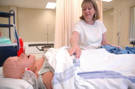 Beckie Kossick sets up one of the new patient simulators located in the Center for Excellence in Health Care Practice.