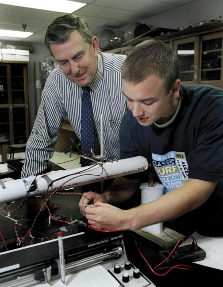 Dr. Kyle Hathcox, professor of physics, works with Junior Joel Fern on a physics project.