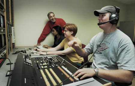 Steve Beverly, assistant professor of communication arts, works with his broadcasting students in the control room of the television studio.
