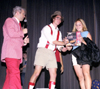 08/26/01 - Freshman Kelly Fern is presented with a lovely parting gift at <i>Right is the Price</i> by Graham Mayfield and host Mark (VanderHaar) Marker.